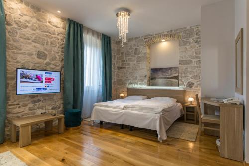 um quarto com uma cama e um espelho na parede em Tifani Luxury Rooms em Split