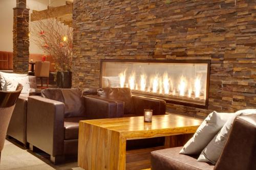 a living room with couches and a fireplace at Coast Kamloops Hotel & Conference Centre in Kamloops
