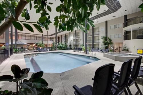 a swimming pool in a building with chairs and a building at Coast Kamloops Hotel & Conference Centre in Kamloops