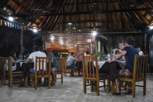 people sitting around a wooden table at Ecohotel Yachay Tayrona in El Zaino