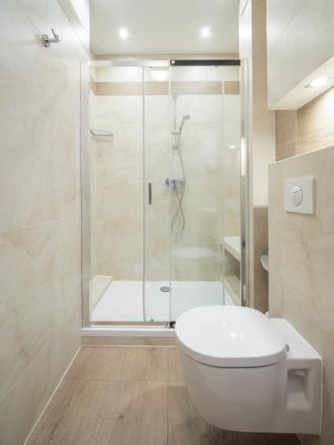 a bathroom with a shower and a white toilet at Hotel Miodowa in Krakow