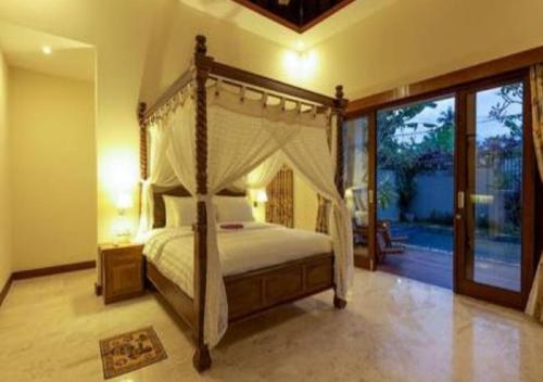 a bedroom with a canopy bed and a large window at Villa Mantika in Senggigi 