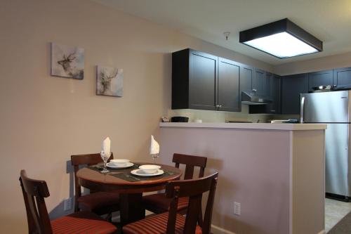 a kitchen with a table and chairs and a refrigerator at Marketplace Lodge by Whistler Retreats in Whistler