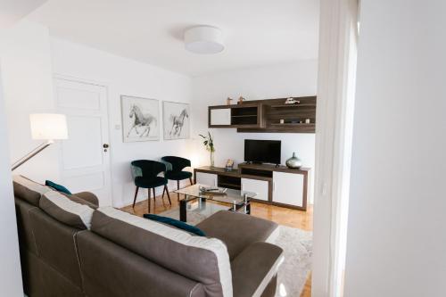 a living room with a couch and a desk at Mumadona Apartment in Guimarães