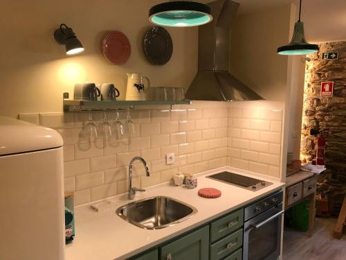 a kitchen with a sink and a stove at Studio Rural in Vilarinho