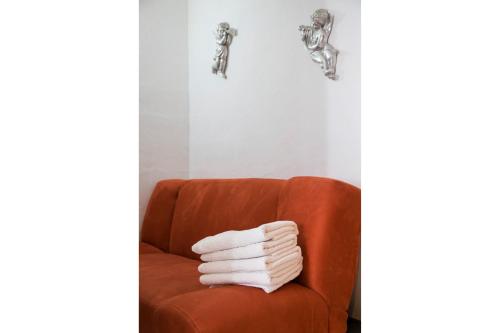una pila de toallas sentadas en una silla naranja en Casa Nona Azul, en Cancún