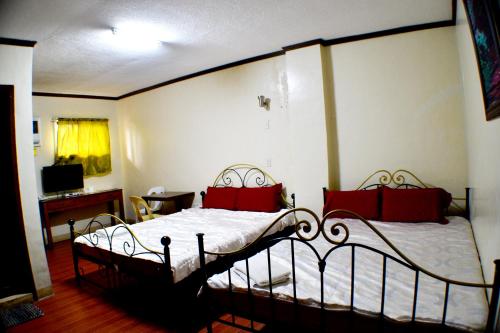 a bedroom with a large bed with red pillows at Rufina's Leisure Center in Tagum