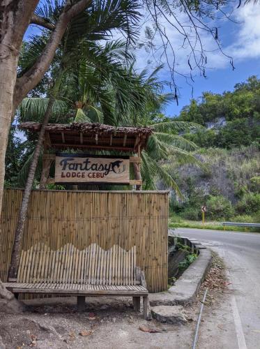 a bench sitting on the side of a road at Fantasy Lodge in Samboan