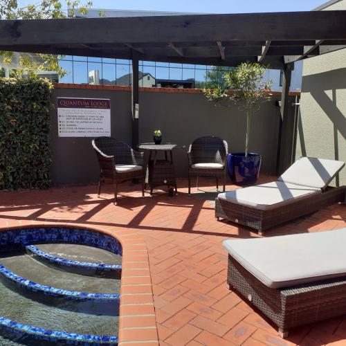 a patio with a table and chairs and a fountain at Quantum Lodge Motor Inn in Hamilton