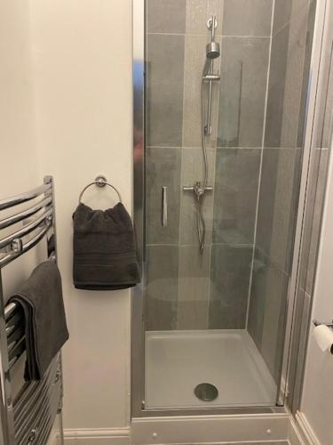 a shower with a glass door in a bathroom at Bentley House with en-suites in Crewe