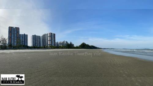 a beach with tall buildings in the background at Sea View & Pool View & WiFi & Netflix at Iman Kazoku TimurBay Ville Studio 2BDR in Kuantan