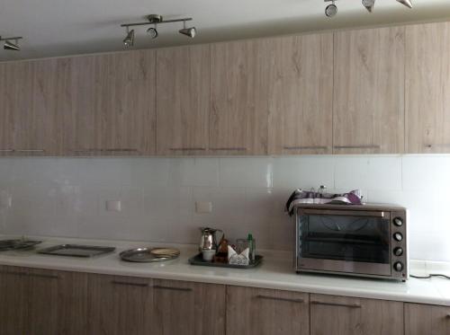 a kitchen with wooden cabinets and a microwave on a counter at San José Hotel Boutique & Spa in La Ligua