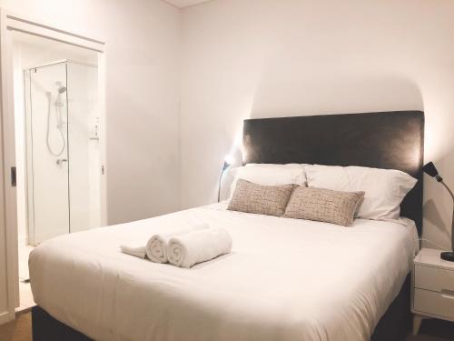 ein Schlafzimmer mit einem großen weißen Bett mit Handtüchern darauf in der Unterkunft South Bank Beautiful river view Tower in Brisbane