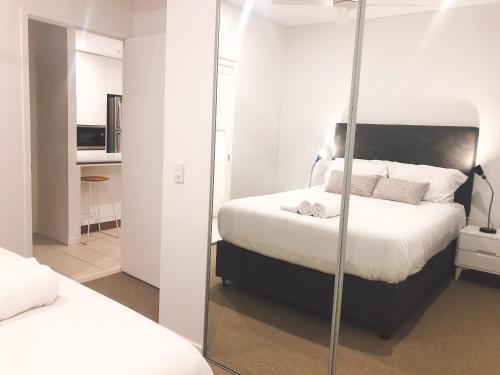 1 Schlafzimmer mit 2 Betten und einem Spiegel in der Unterkunft South Bank Beautiful river view Tower in Brisbane