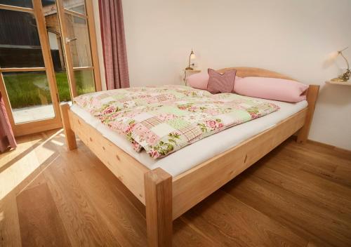 シュリールゼーにあるFerienwohnung Glaserhäusl Seeblickのベッドルーム1室(毛布付きの木製ベッド1台付)