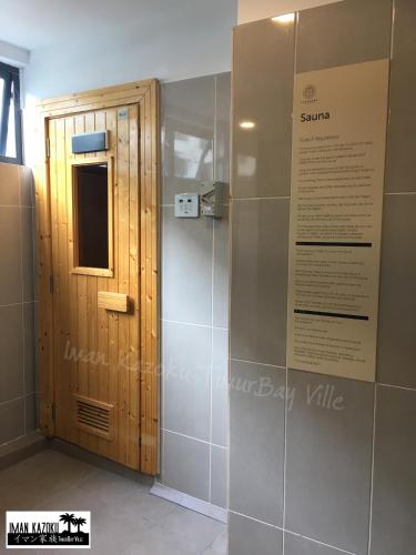 a bathroom with a shower and a wooden door at Sea View & Pool View & WiFi & Netflix at Iman Kazoku TimurBay Ville Studio 2BDR in Kuantan