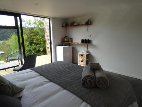 1 dormitorio con 1 cama con toallas en Kaiteriteri Abel Tasman Inlet Views, en Kaiteriteri