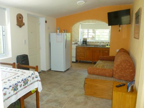 eine Küche mit einem Sofa und einem weißen Kühlschrank in der Unterkunft RINCÓN SERENO... Un lugar para disfrutar.... in Villa General Belgrano