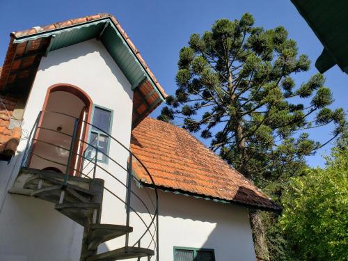 a building with a staircase next to a tree at marcita chalé in Monte Verde