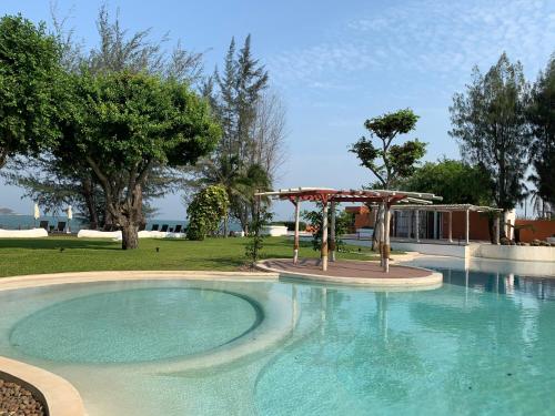 a swimming pool with a gazebo in a yard at Mexican Beachfront Condo in Khao Tao