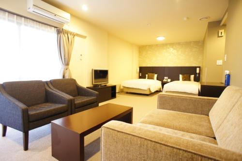 a hotel room with two beds and a living room at Hakone Forest of Verde in Hakone