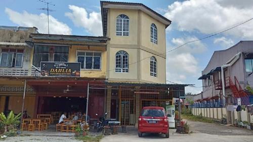 a red car parked in front of a building at Homestay Taman Maktab Pengkalan Chepa in Pengkalan Cepa
