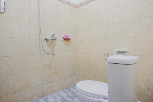 La salle de bains est pourvue d'une douche et de toilettes. dans l'établissement RedDoorz Syariah near Kebun Raya Liwa, à Lampung
