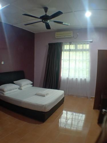 a bedroom with a bed and a ceiling fan at TEBiNG Guest House Taman Negara Malaysia Kuala Tahan in Kuala Tahan