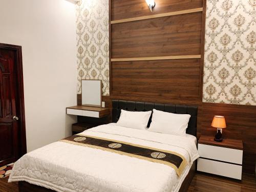 a bedroom with a bed with a wooden headboard at AN NGỌC HOTEL in Can Tho