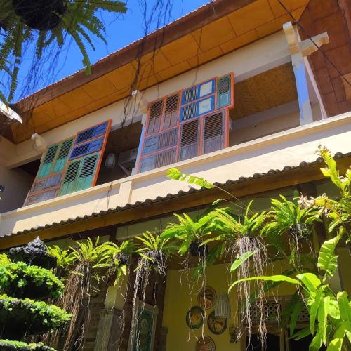 a house with colorful windows and palm trees at Samblung Mas House in Denpasar