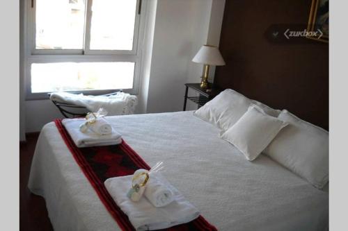 a hotel room with a bed with towels on it at Departamento Ohiggins I in Salta
