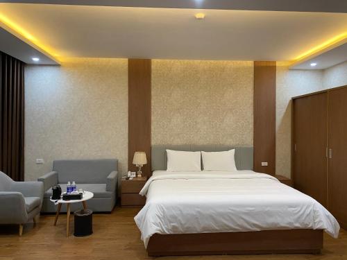 um quarto com uma cama grande e 2 cadeiras em Galaxy Grand Hotel em Sơn La