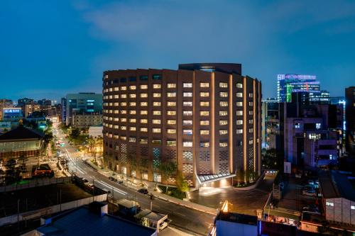 a tall building in a city at night at Hotel Indigo Taipei North by IHG in Taipei