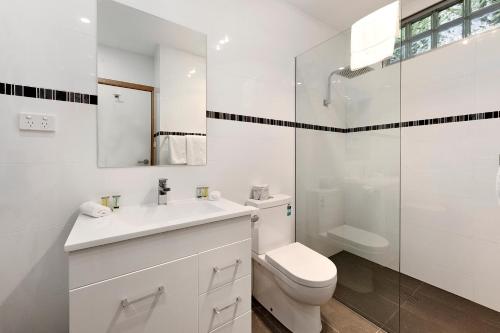a white bathroom with a toilet and a shower at Commodore Regent Launceston in Launceston
