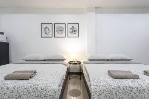 two beds sitting next to each other in a room at P1 Silom Pan large room full kitchen WIFI 4-6pax in Bangkok