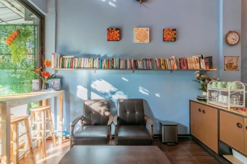 a chair in a room with a blue wall at Phobphan Hostel in Bangkok