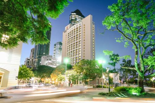 una calle de la ciudad por la noche con edificios en Stamford Plaza Brisbane en Brisbane