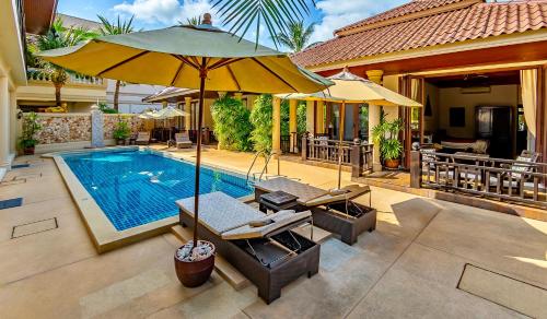 a house with a swimming pool with an umbrella at Sibaja Palms Sunset Beach Luxury Apartments in Taling Ngam Beach