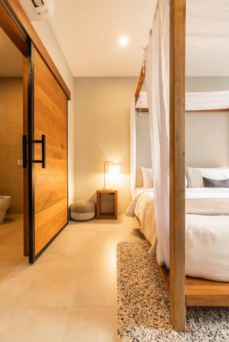 a bedroom with a bed and a wooden door at Zee Luxury Boutique Hotel in Hinkong