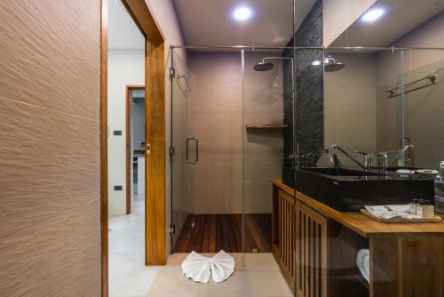 a bathroom with a sink and a glass shower at Zee Luxury Boutique Hotel in Hinkong