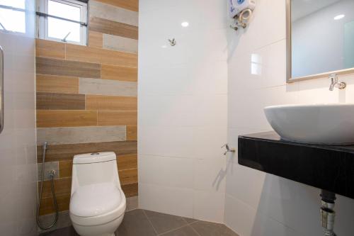 a bathroom with a white toilet and a sink at Lazy Cat Home At Gaya Street in Kota Kinabalu