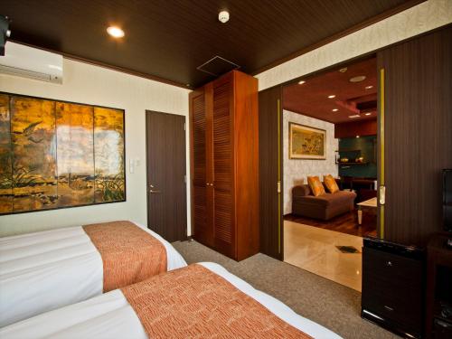a bedroom with a bed and a living room at Hotel Palm Royal Resort Kokusai Street in Naha