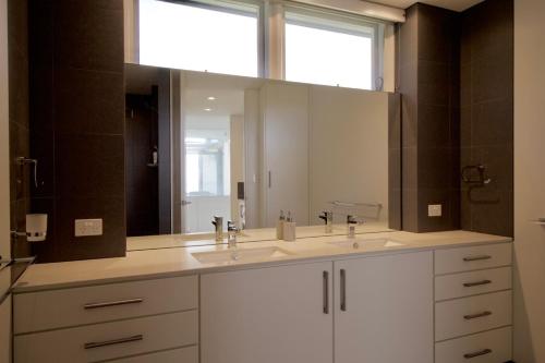 a bathroom with two sinks and a large mirror at Boathouse - nearly in the water and wonderful views in Augusta