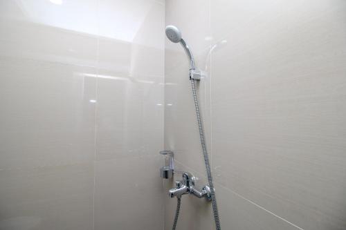 - une cabine de douche avec un microphone dans l'établissement RedDoorz Plus @ Terban Residence, à Yogyakarta