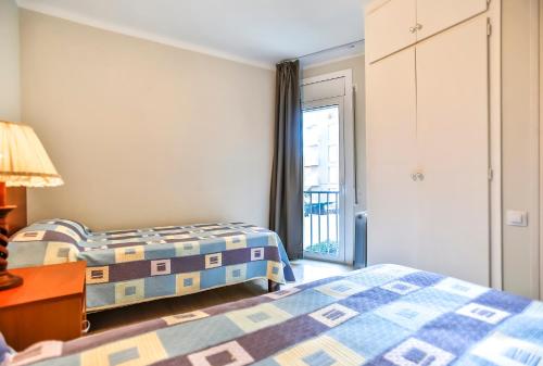 1 dormitorio con 2 camas y ventana en Vacaciones perfectas 2, en Segur de Calafell