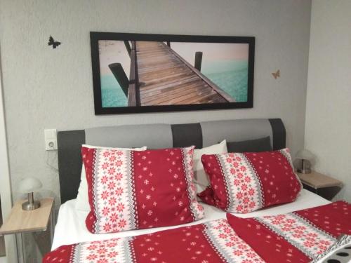 Schlafzimmer mit einem Bett mit roten und weißen Kissen in der Unterkunft Ferienwohnung Graul in Wernigerode
