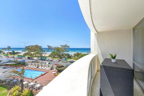 a balcony with a view of a pool and the ocean at Focus Apartments in Gold Coast
