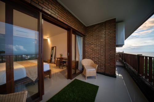 a bedroom with a bed and a view of the ocean at Dreamland View in Uluwatu