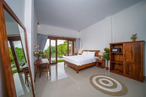 a bedroom with a bed and a large window at Dreamland View in Uluwatu