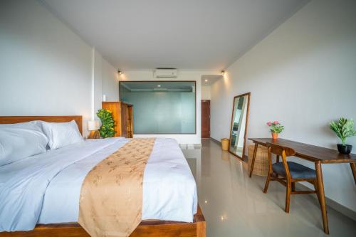 a bedroom with a bed and a table and a desk at Dreamland View in Uluwatu